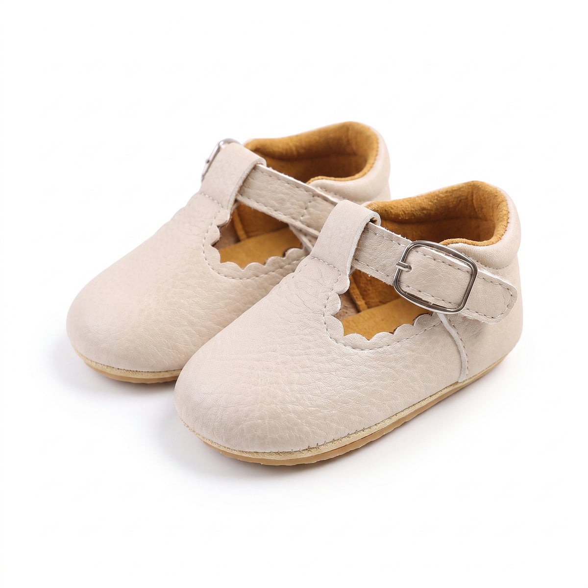 mocassins bébé beiges en cuir chaussons en paire sur fond blanc