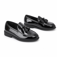mocassins enfant noir verni brillant paire sur fond blanc